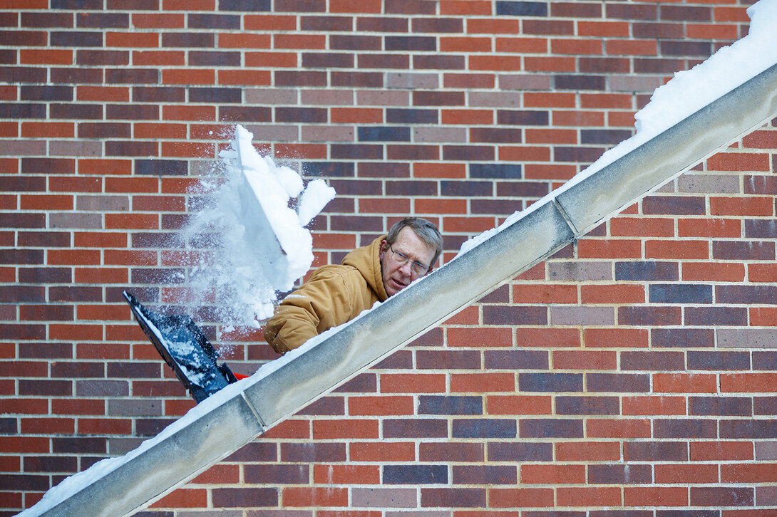 Lenny Hill shovels the emergency exit steps on the east side of the Nebraska Union as campus opened on Jan. 27. The first day of the spring semester was delayed two days by a record-breaking snow storm on Jan. 25.