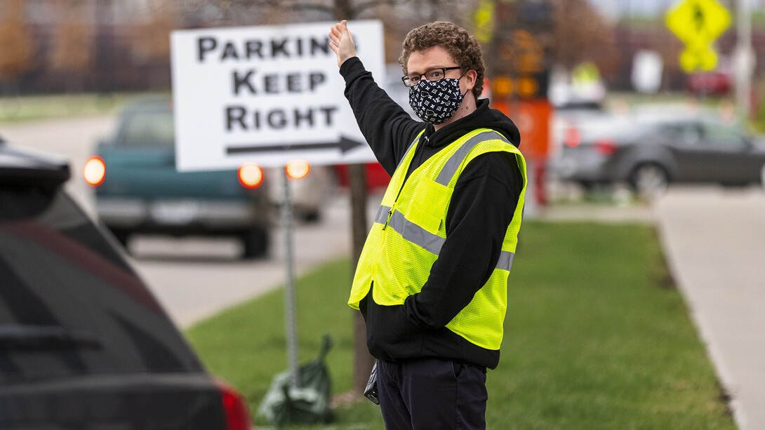 Noah Schwendeman directs traffic along Pinnacle Arena Drive as people arrive for their vaccine on April 7. Schwendeman said he volunteered for the clinic to help the community edge toward a return to normal.