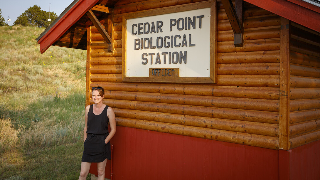 Sarah Kaizar stands next the cabin-like office at Cedar Point Biological Station.