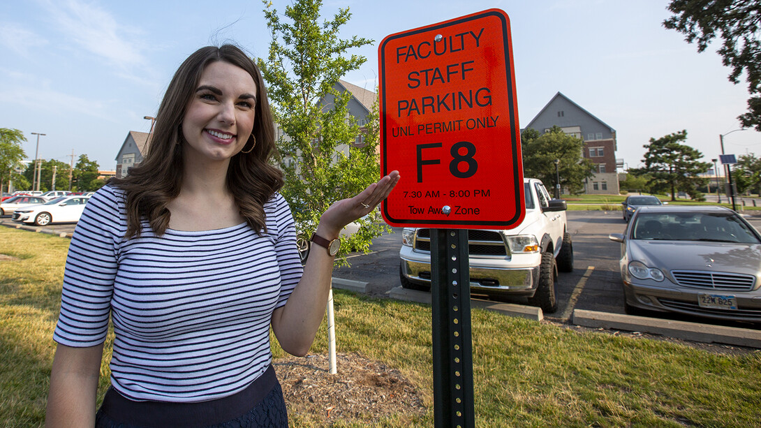 Bonnie Martin stands next to her reserved parking sign near Nebraska Hall.