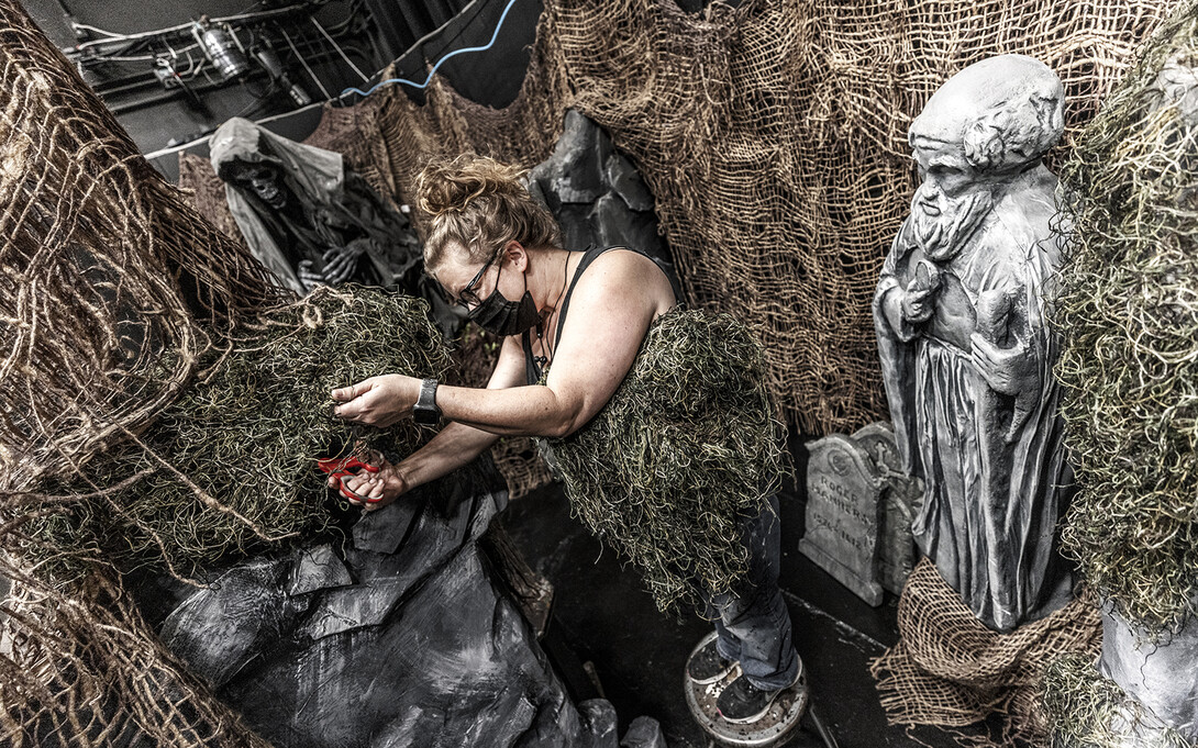 Jill Hibbard, production designer, works on the scenery amongst the “ShakesFear” statuary.  