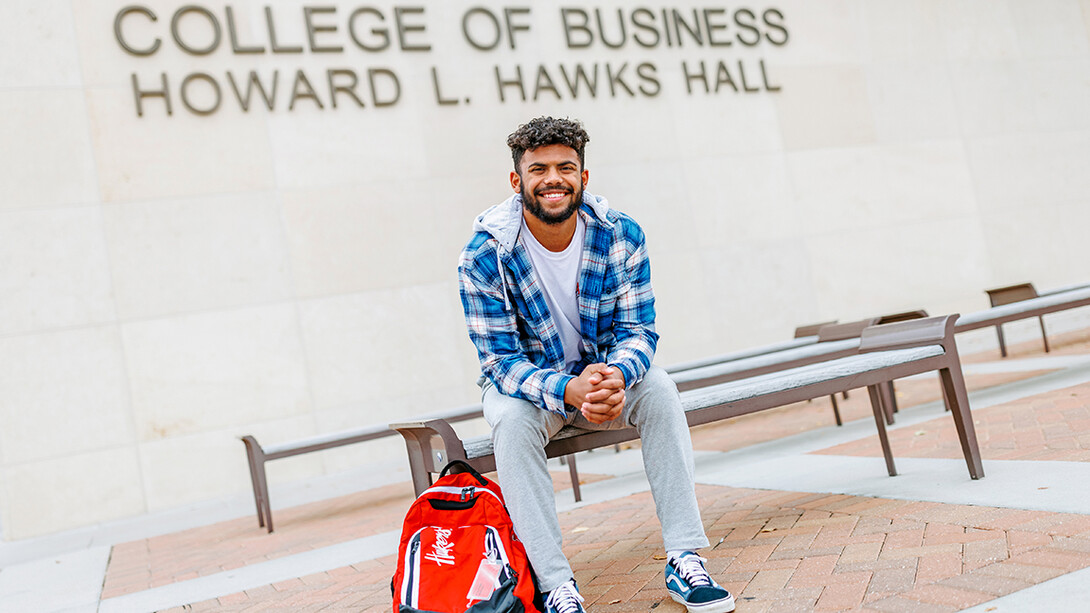 Derek Branch sitting on a bench outside of Howard Hawks Hall.