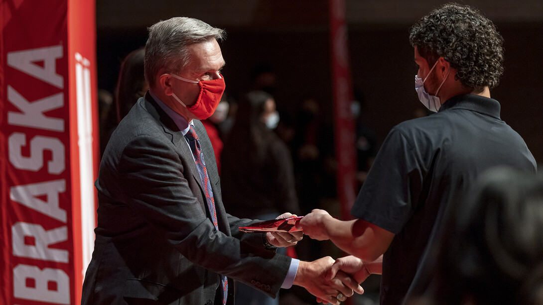 Yael Blanco-Zamudio (right) shakes hands with Chancellor Ronnie Green after receiving an admission certificate during a ceremony at Omaha South High School. Green presented the certificates to Nebraska College Preparatory Academy seniors at Omaha South and Omaha North high schools on Nov. 2.