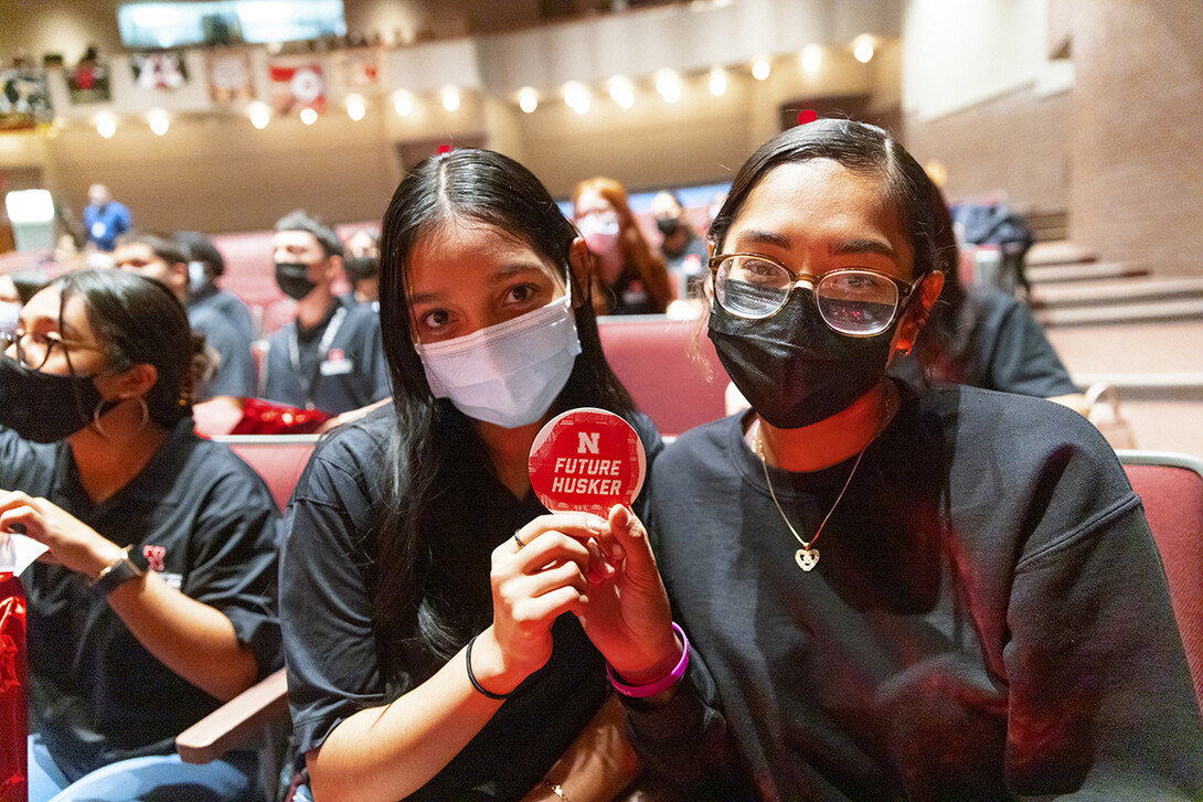 Omaha South seniors Marian Rodriguez and Lizbeth Valente Alday hold up a future Husker sticker from a swag bag they received during the Nov. 2 ceremony with Chancellor Ronnie Green.