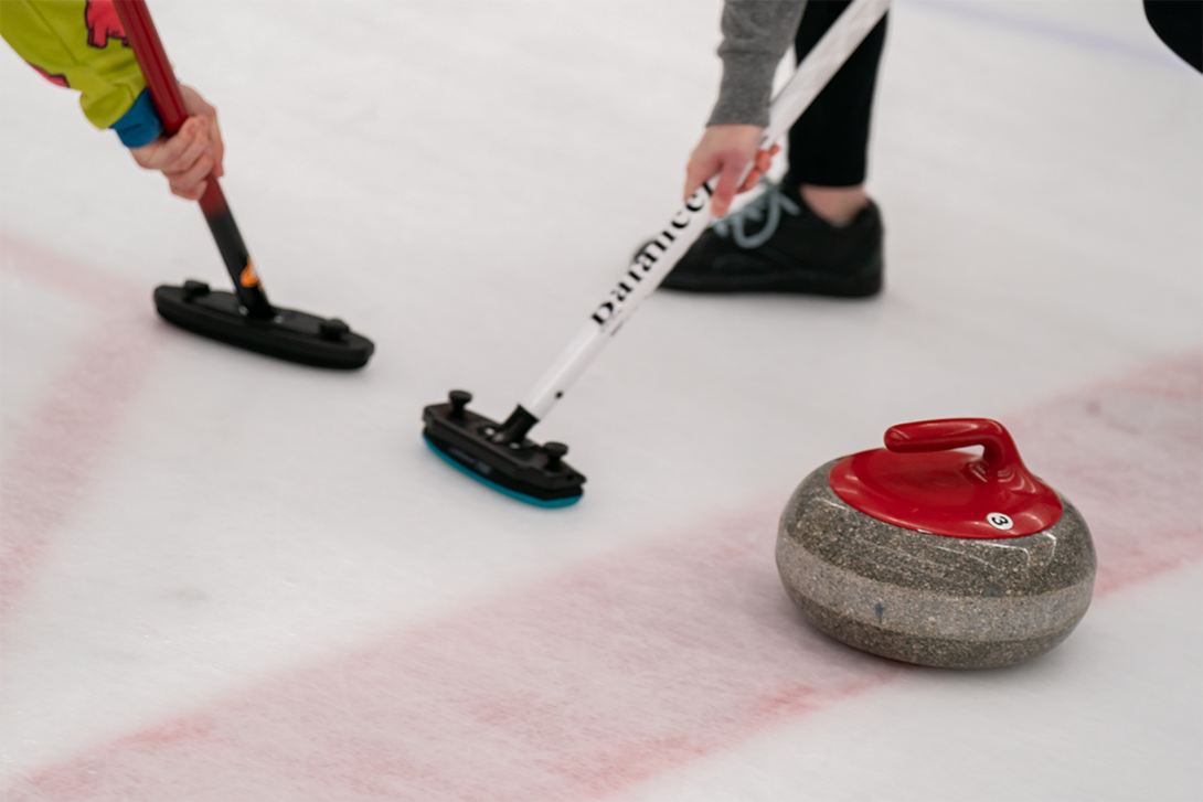 A curling stone and brooms.