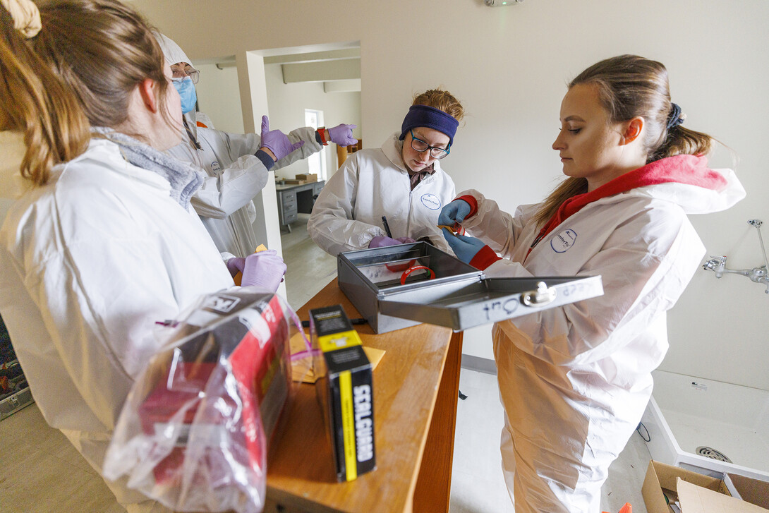 Brandy Branscom (center) and Mariya Dudin (right) log in evidence at the crime scene. 