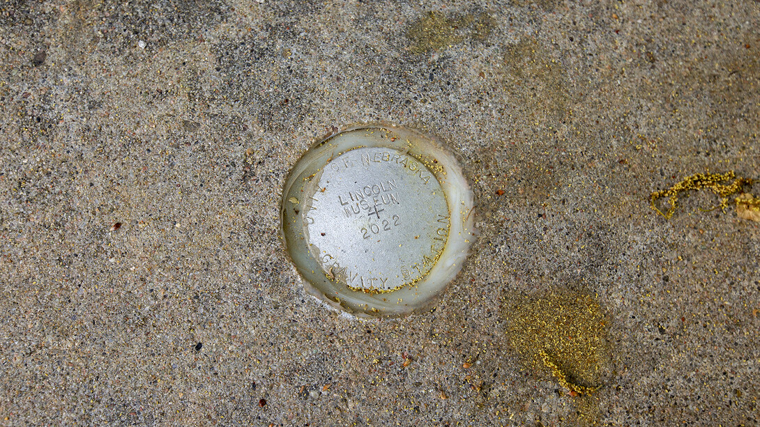 A silver disc marks one of the gravity base stations established by Guthrie. the locations are used to calibrate gravimeters and can be tied to data from gravity surveys across Nebraska and beyond.