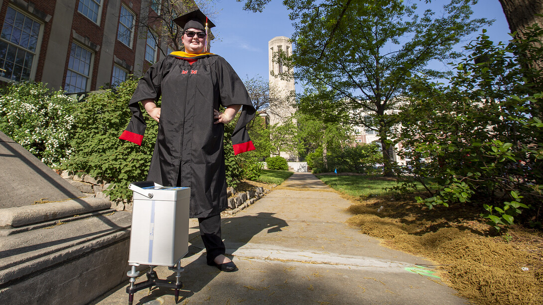 Kris Guthrie stands next to a gravimeter positioned at the gravity base station she established outside of Morrill Hall. The station — and another located by Mueller Tower — are the first on campus. They were established through part of Guthrie's graduate program in earth and atmospheric sciences.