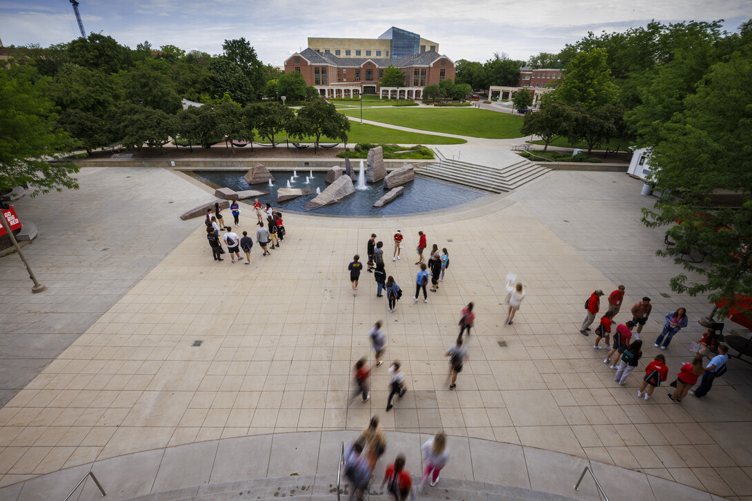 Students walk through campus between the Nebraska Union and the green space, near Broyhill Fountain