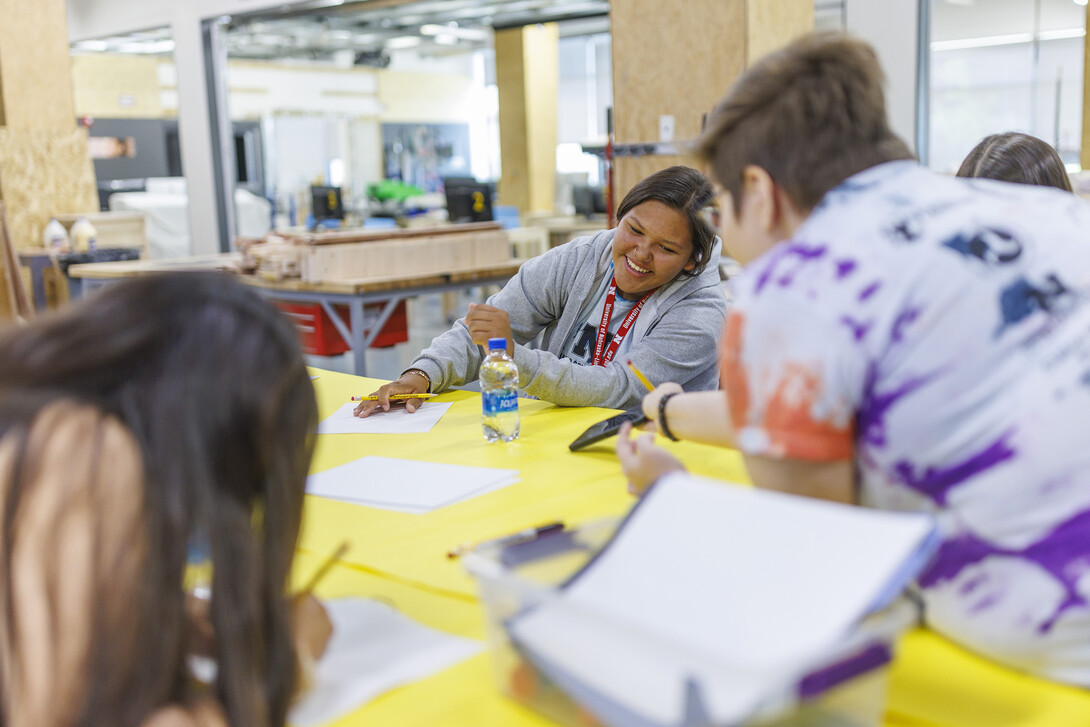 Alana Denney laughs while looking at images for her design with academy mentor Shiloh King.