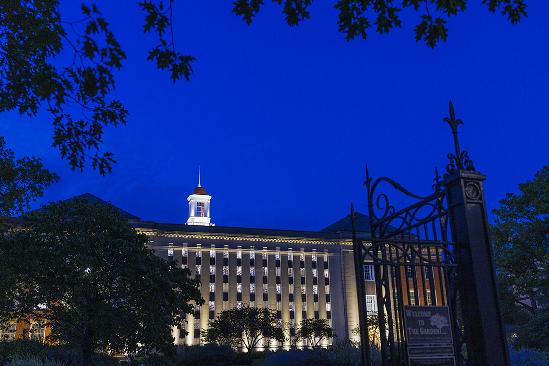 Love Library is illuminated against the sky at dusk.