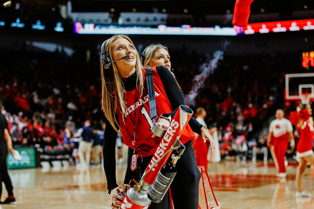 Ashley Beckman works the T-shirt machine on the court during a Husker Basketball game