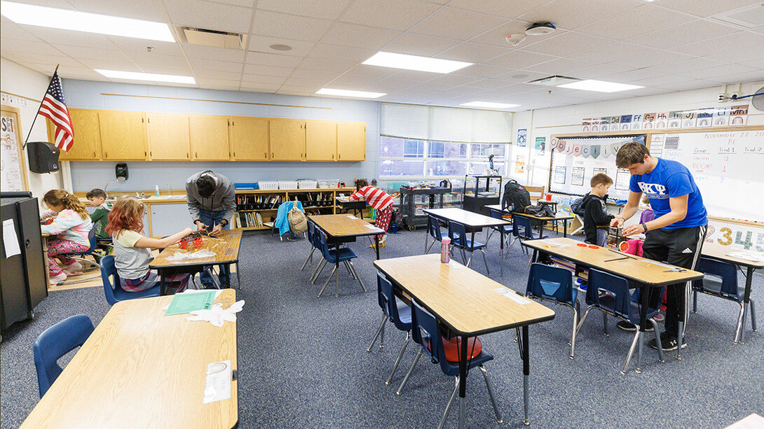 Nebraska honors students Spencer Knight, right, and Rohan Tatineni, left, work with Riley Elementary students in their after-school STEM club.