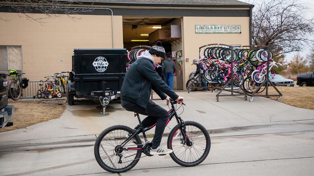 Jacob Dalton test rides a bike outside the Lincoln Bike Kitchen after making a repair. The work wasn't perfect, so Dalton ended up taking it back inside for additional adjusting.