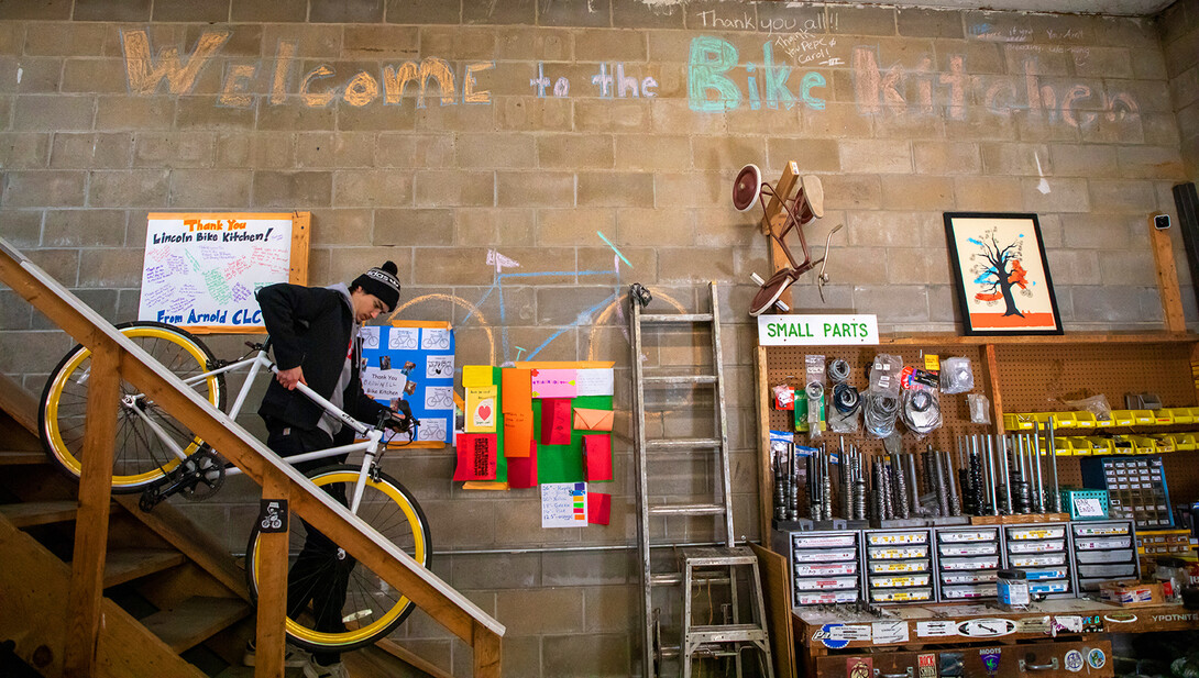 Jacob Dalton carries a bike down from storage in the Lincoln Bike Kitchen.