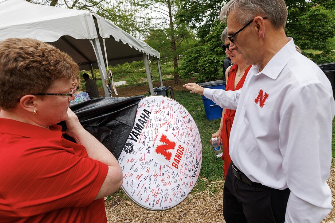 Carolyn Barber, Ron and Carol Cope Professor of Music and director of bands, presented the Greens with a drumhead signed by members of the Cornhusker Marching Band.