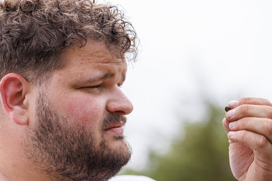 Dalton Carder, a senior in anthropology, looks at a piece sifted from his dig area.