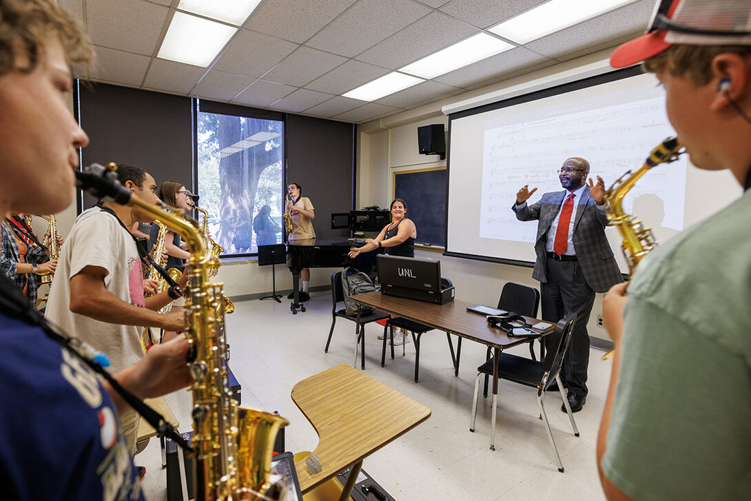 Chancellor Rodney Bennett follows the direction of Drum Major Steffani Nolda, center, and saxophone section leader Cyphers Stewart as Bennett helps lead the saxophone section in the fight song.