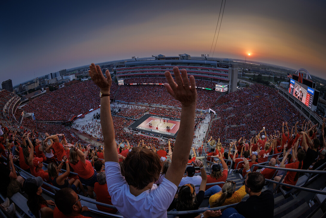 The crowd does the wave during a time out as the sun sets over Memorial Stadium.