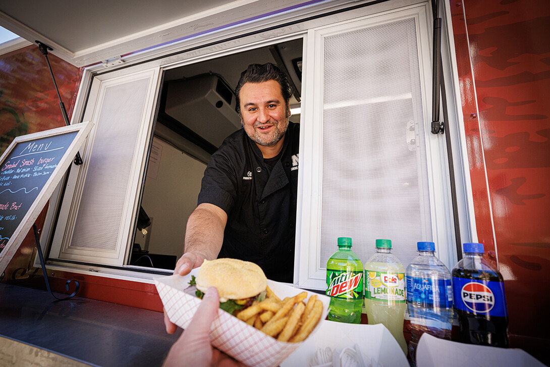 Octavio “Otto” Meza, production manager for Housing and Dining Services, waits on customers at the Harper's Smokehouse Food Fruck parked outside Avery Hall.