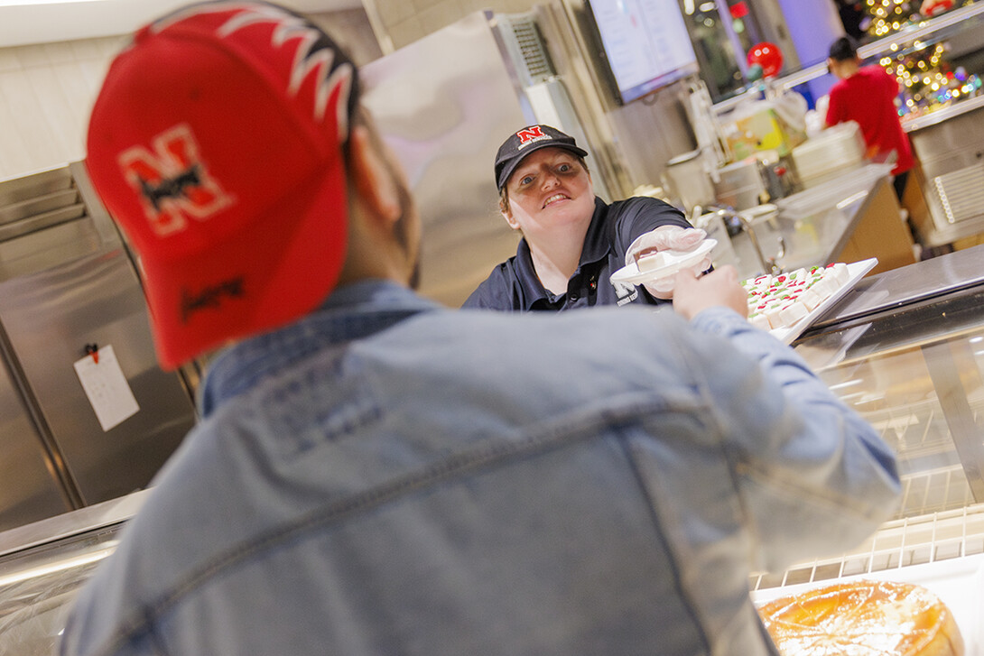 Gretchen Hamilton serves up a student’s choice of petit fours at the Cather Dining Complex.