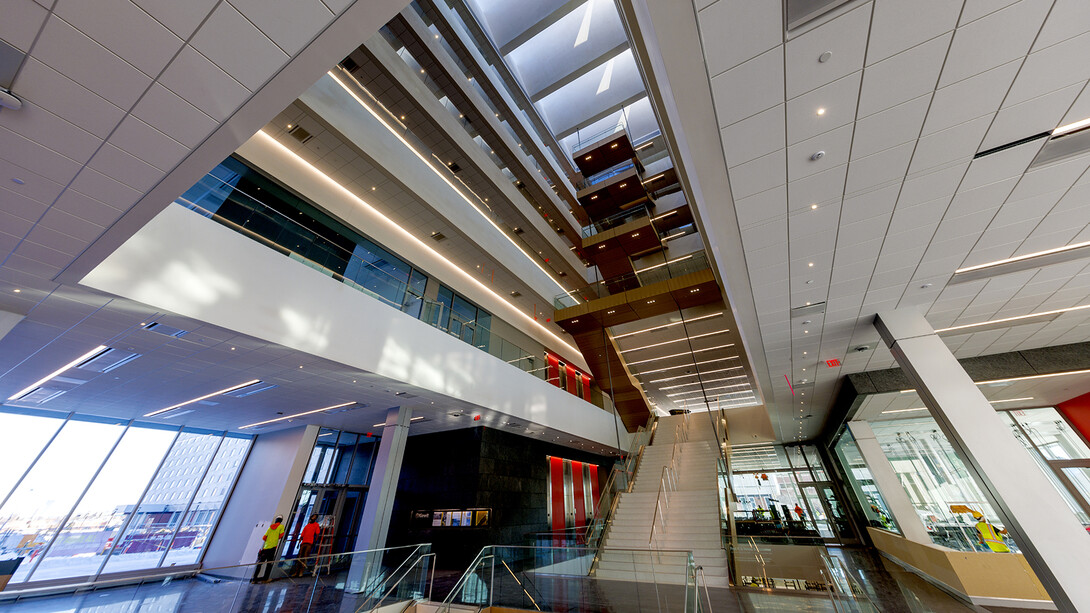 Photo showing Kiewit Hall's central staircase rising nearly 100 feet from the basement to the sixth floor. Five stories of the staircase hang from the roof rather than being supported in a more traditional manner on the ground.