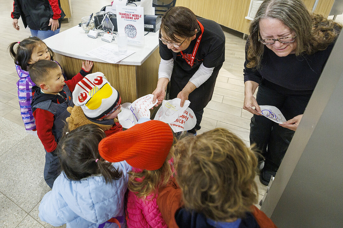 Children crowd in to give appreciation hearts to the food service workers in the Nebraska East Union.