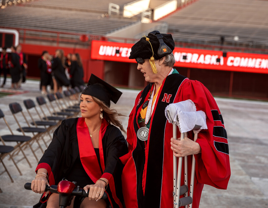 Vanessa Gorman helps Kaylee Bray (left), a Psychology major with a knee injury, to her seat.