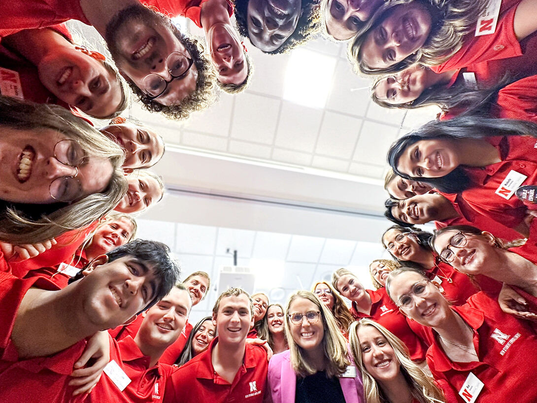 Jenni Brost and New Student Enrollment leaders standing in a circle looking down at a camera for a photo.