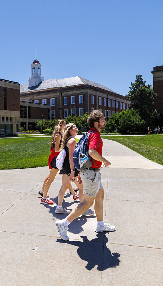 An NSE orientation leader guides students across campus by Love Library.