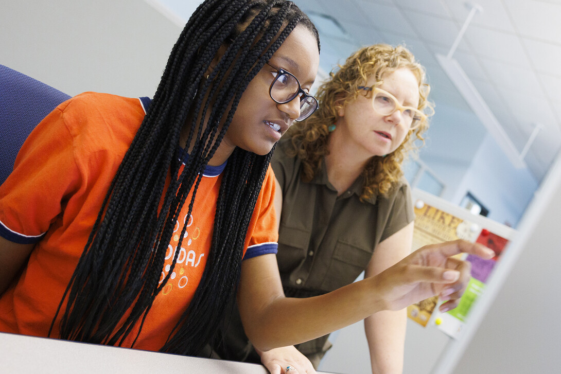 Zoe Williams, a Howard University student, works with Katrina Jagodinsky, associate professor of history, to help decipher writing on an old legal document. 