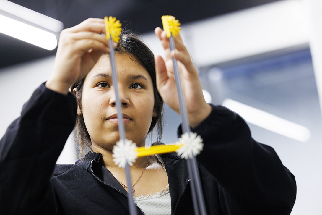 Mida DeAnda builds her tower to be tested on the shake table.