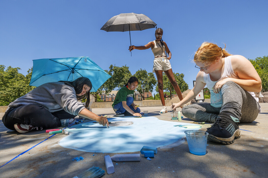 Evelyn Whitlock, Claudia Figueroa and Sarah Paarden work on a chalk painting as part of the 6-week summer Upward Bound program. 