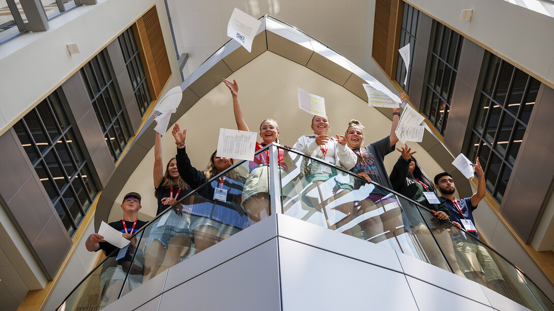 Students celebrating by throwing papers off a balcony.