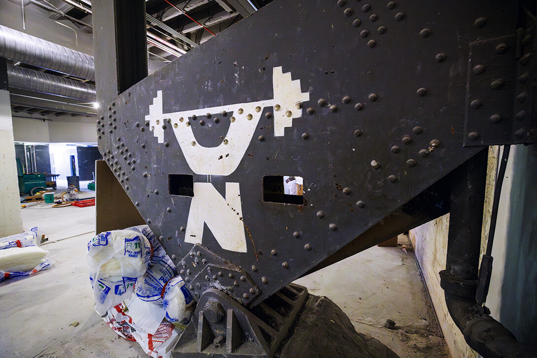 Stenciled to a girder was a stylized Nebraska weightlifter from when the area was a weight room. Construction continues to renovate the locker rooms and a new weight training and conditioning area.