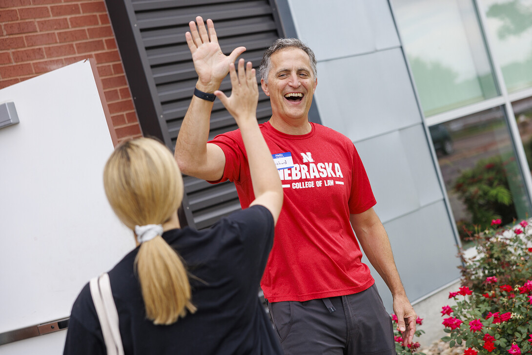 Richard Moberly, dean of the College of Law, welcomes a student with a high five as she arrives for the service-learning project at Habitat for Humanity's ReStore. 