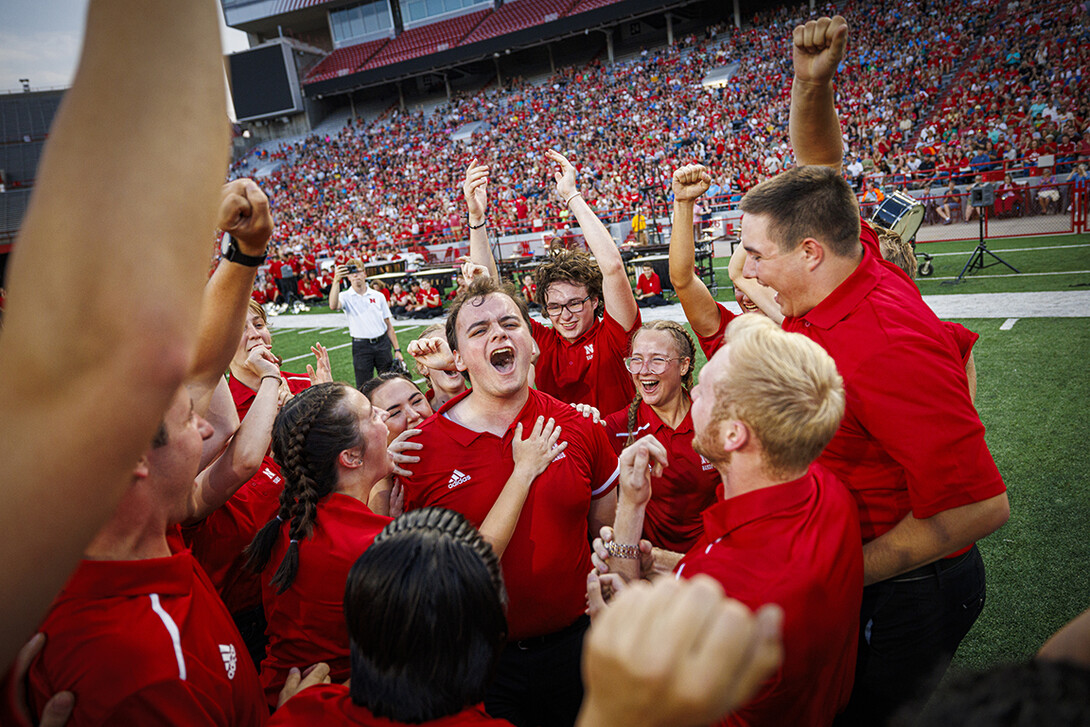 A group of Cornhusker Marching Band members celebrate following a competition during the annual exhibition in Memorial Stadium.