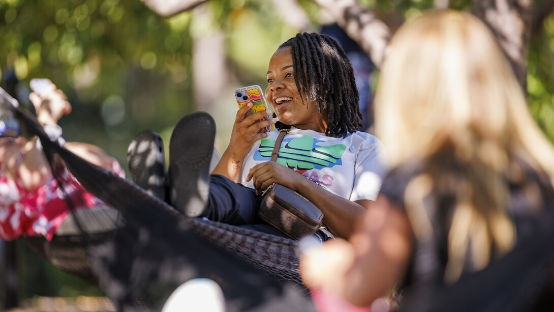 Jessica Prince, a first-year student, chats while swinging in a hammock outside the Nebraska Union.