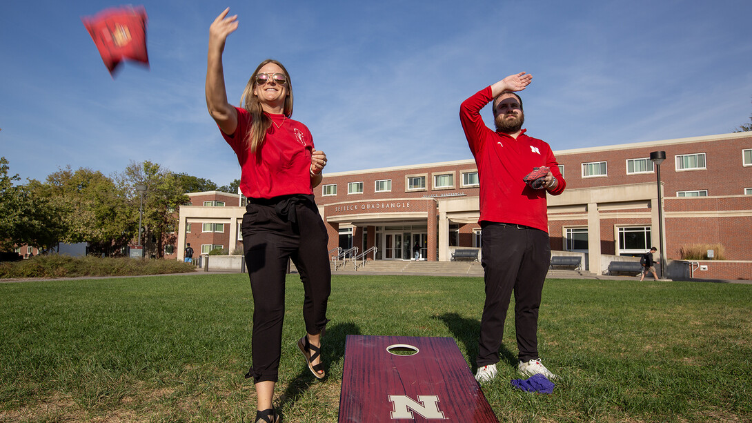 Nebraska's Hollie Swanson (left) and Logan Kahlor take practice cornhole tosses while setting up the 2024 homecoming yard games competition on the Meier Commons on Oct. 1.