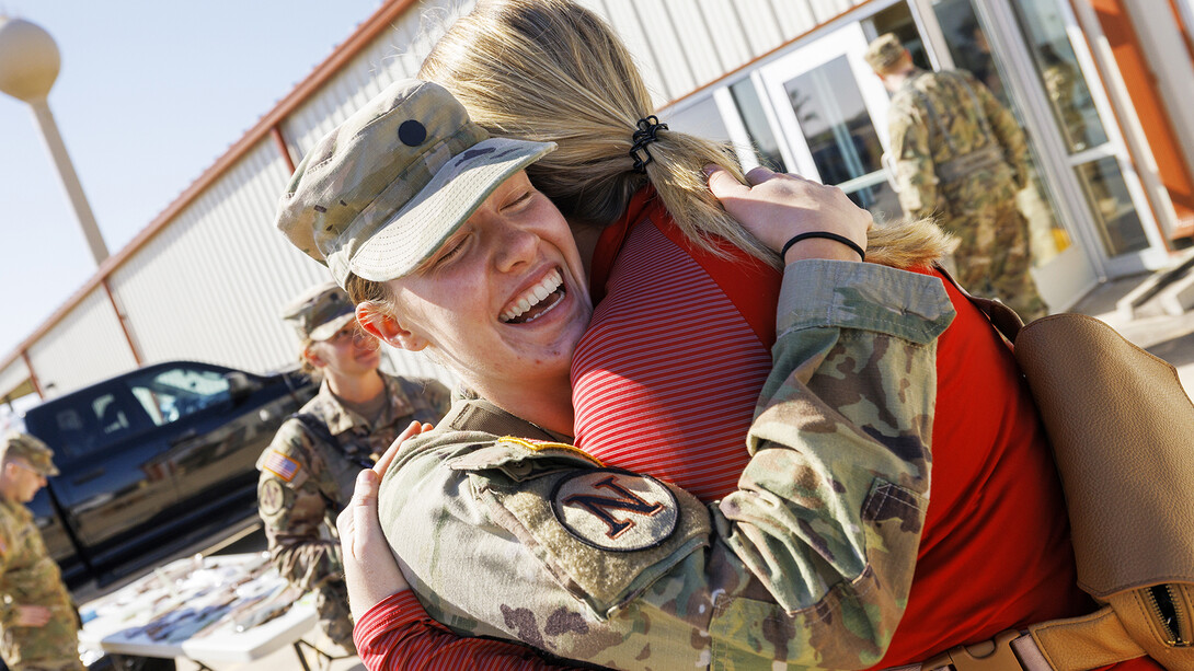 Cadet Natalie Karrels, a senior in supply chain management, hugs Erin Burnette, director of the Nebraska Business Honors Academy, between ROTC exercises. Karrels nominated Burnette to participate in the Army ROTC flight.