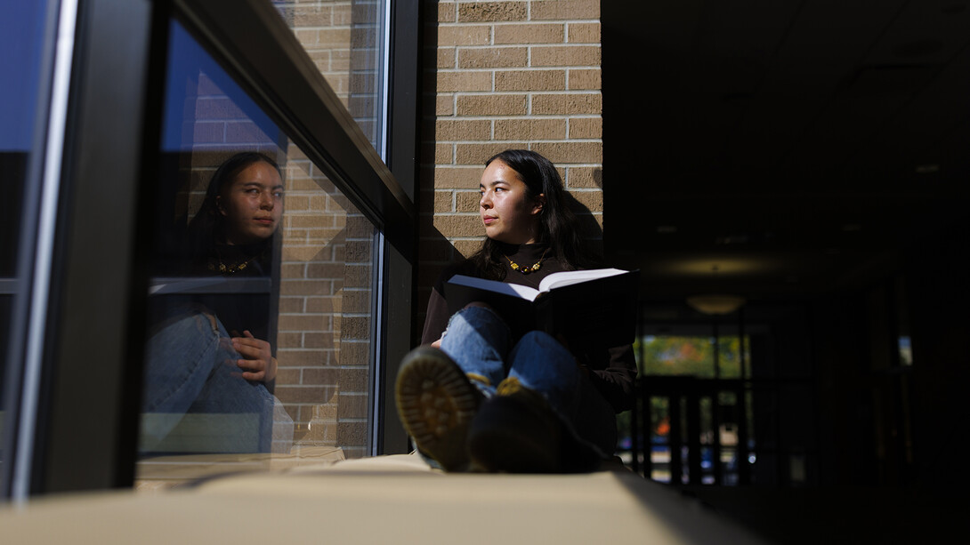 During a break from studying in a College of Law hallway, Hana Pham appears to be looking at her reflection while glancing outside. Pham, a first-year law student, is a UNL alumnus, having studied sociology and graduating in May 2023. Learn more about Pham and her excitement for being a part of Nebraska Law at https://go.unl.edu/6zew.