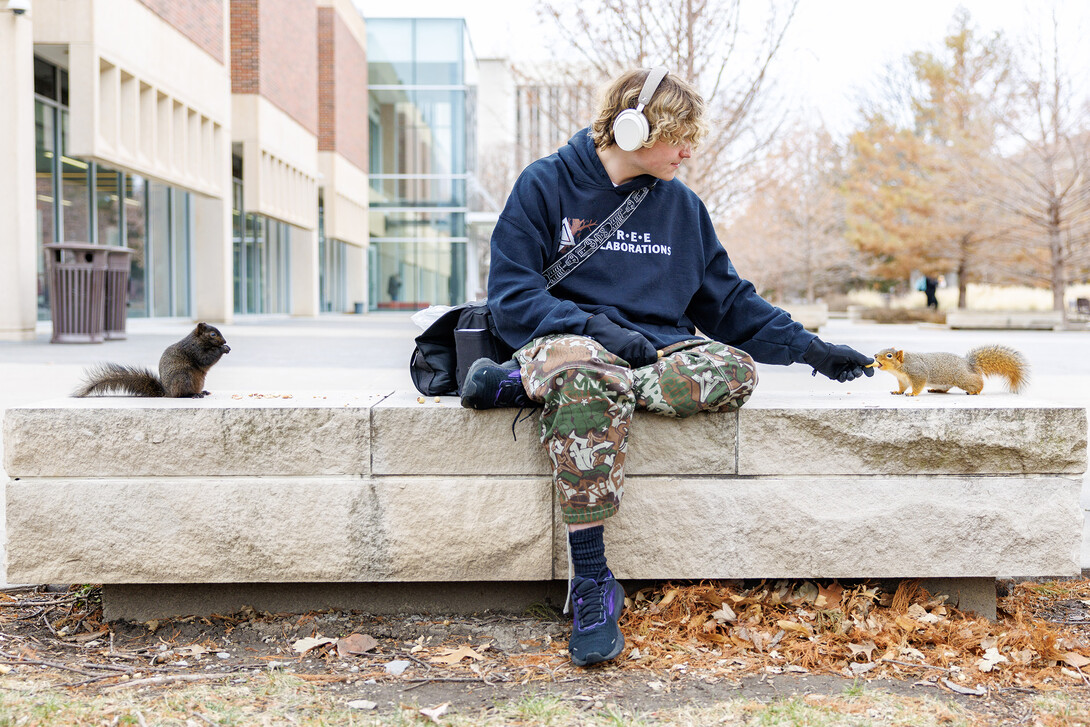 Dalton Dailey, junior, feeds squirrels outside of Love Library. December 17, 2024