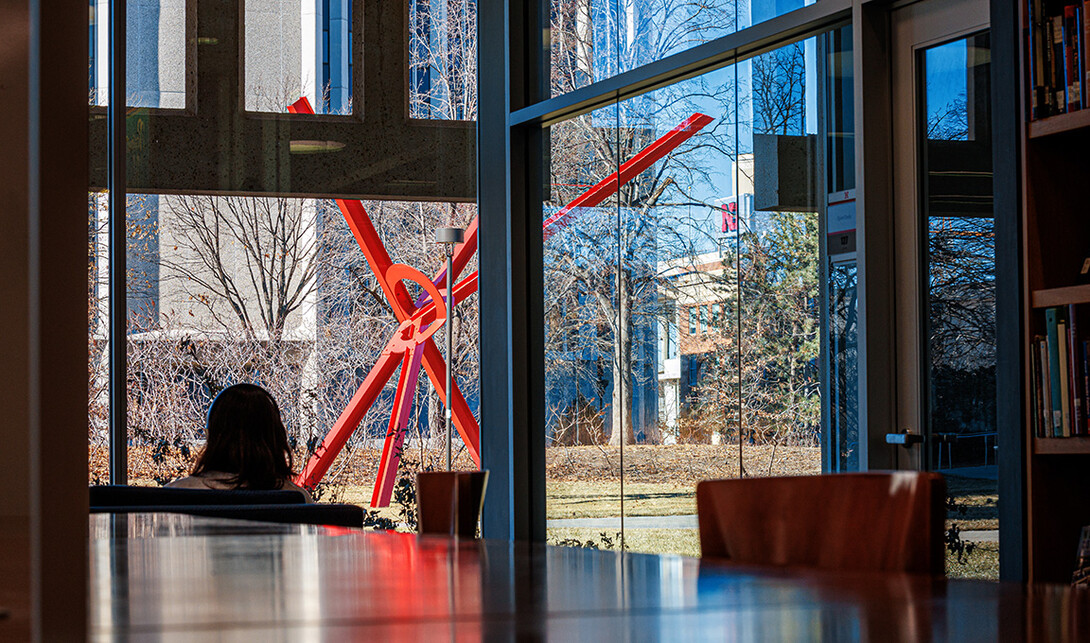 A photo view of the red sculpture, Old Glory, from the vantage of Love Library.