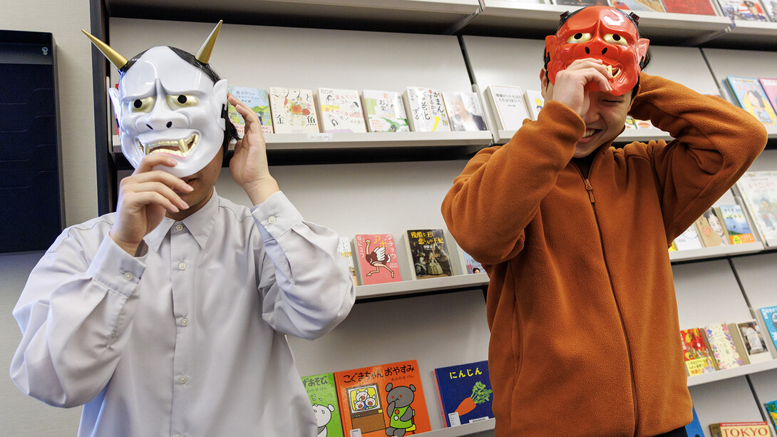  Jerry Zhu (left) and Hokuto Okabe put on Japanese oni (demon) masks at the start of the bean-throwing ritual in the Kawasaki Reading Room on Jan. 31. 