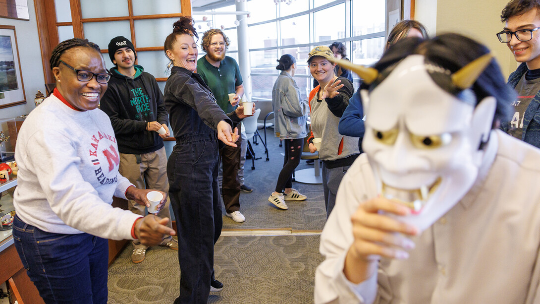 Cheryl Muregerera (left), a Kawasaki Reading Room worker and graduate student in educational administration, leads students in throwing roasted soybeans to drive away “demons” as part of Japan’s mamemaki ceremony. The ritual is intended to drive away evil spirits and welcome good fortune.