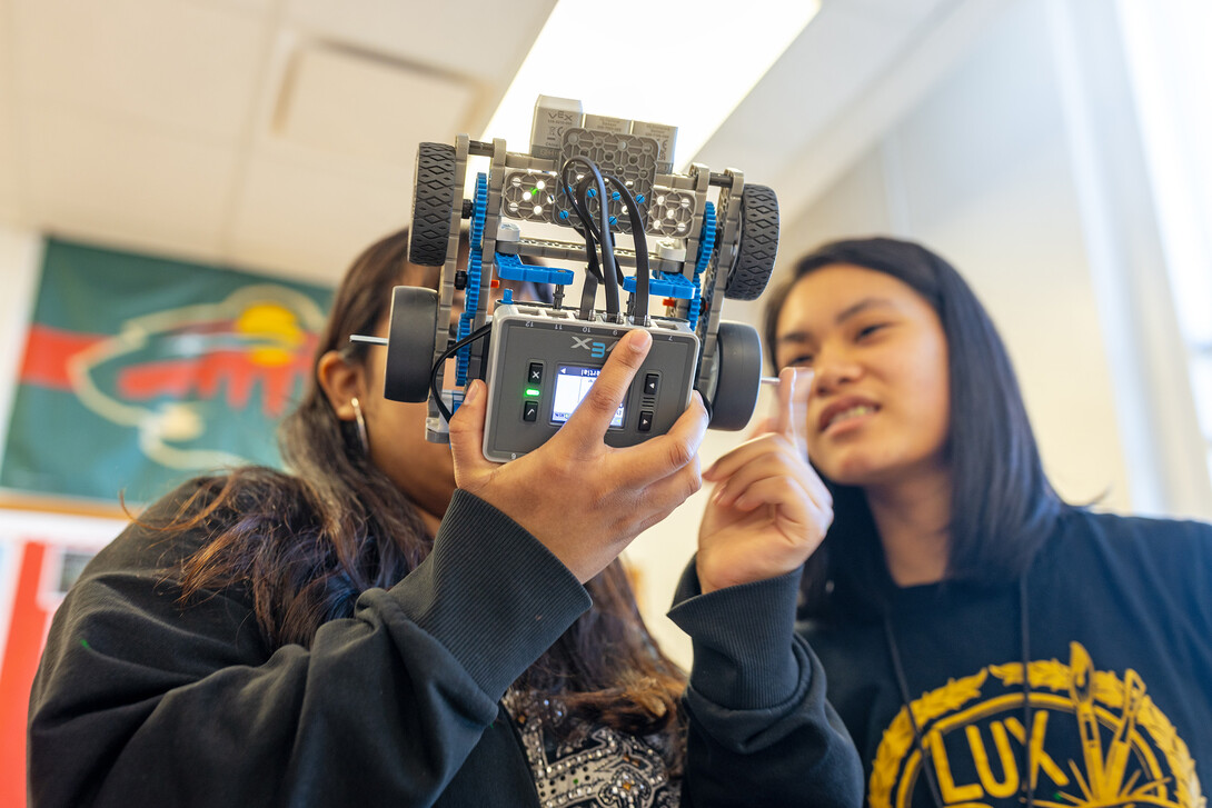 Tran works with another student to figure out why one wheel isn't spinning.