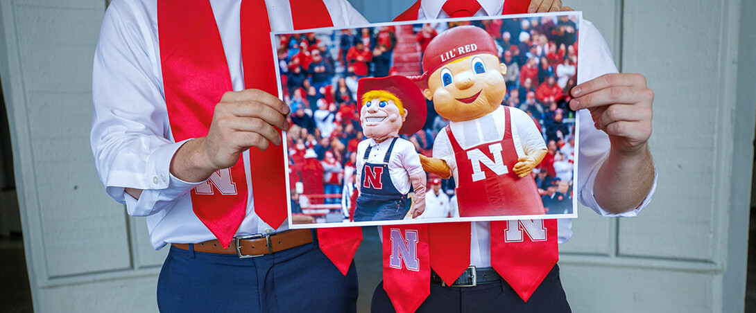 Ben Hastreiter or Brady Moylan hold a photo of themselves as Herbie and Lil'Red.