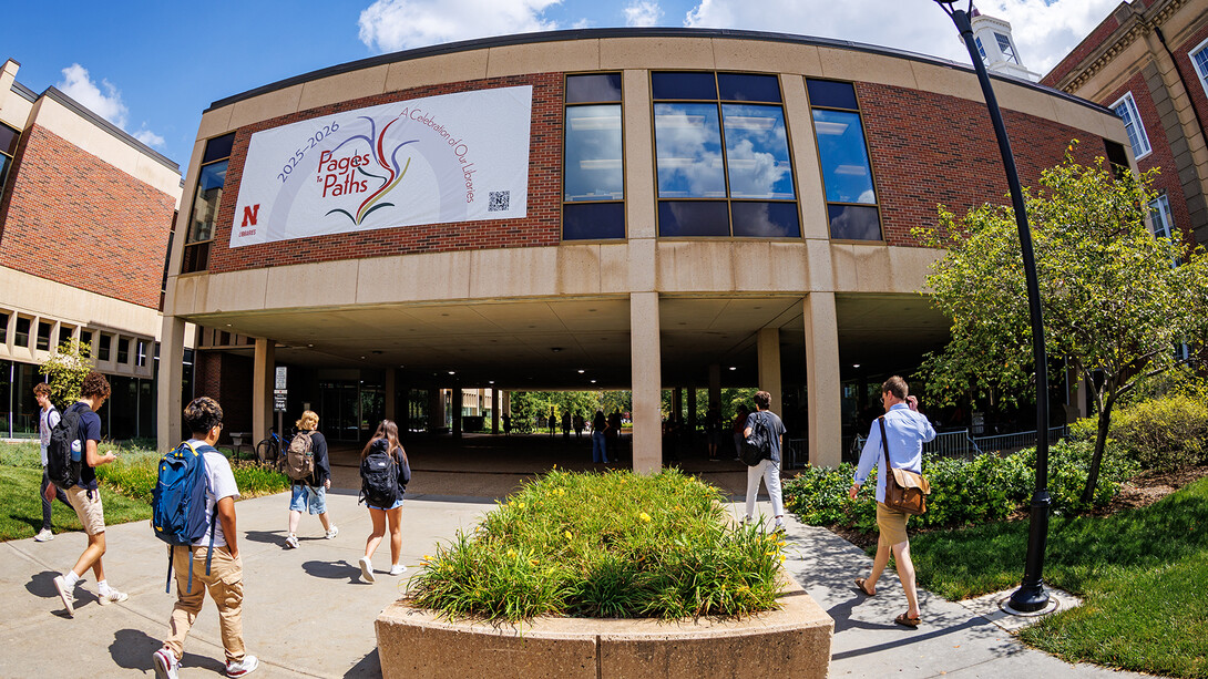 Huskers walk across City Campus under the link to Love Library. The University Libraries are celebrating Pages to Paths, an initiative that marks the history, people and multiple roles of the University Libraries.