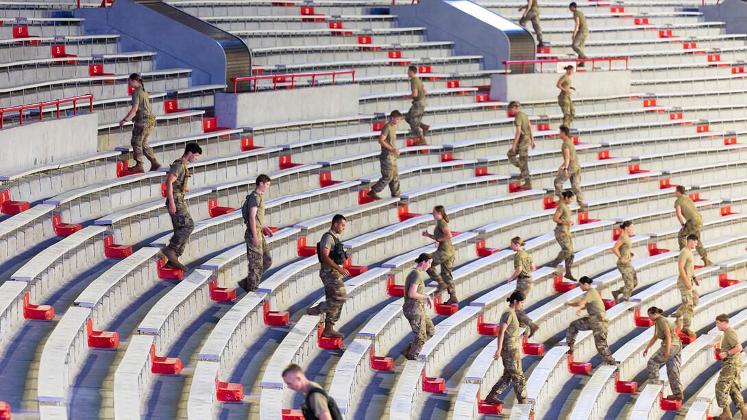 ROTC cadets climb stairs in Memorial Stadium for a 9/11 observance.