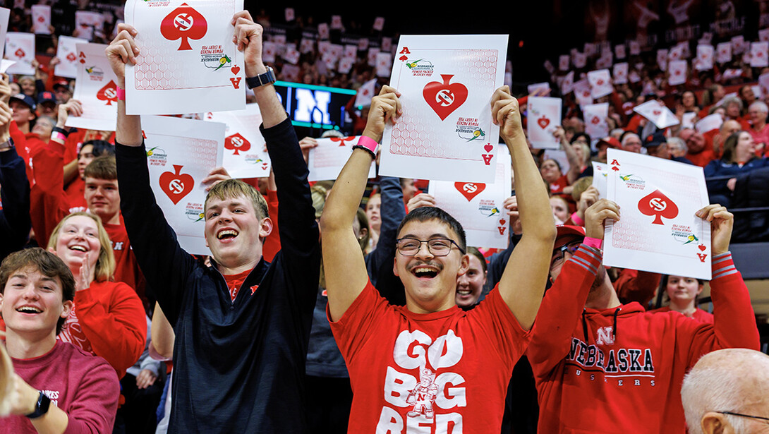 Students hold up Ace cards, a throwback to when they played in the Coliseum and would put them on every seat.